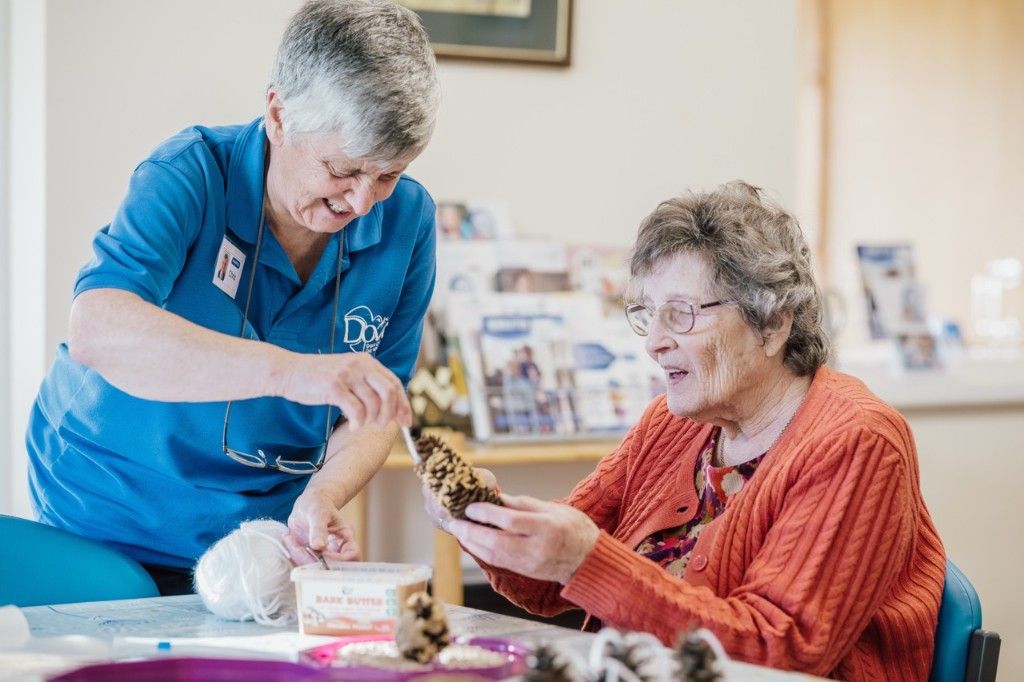 A Dove Cottage team member and patient enjoying a craft activity together