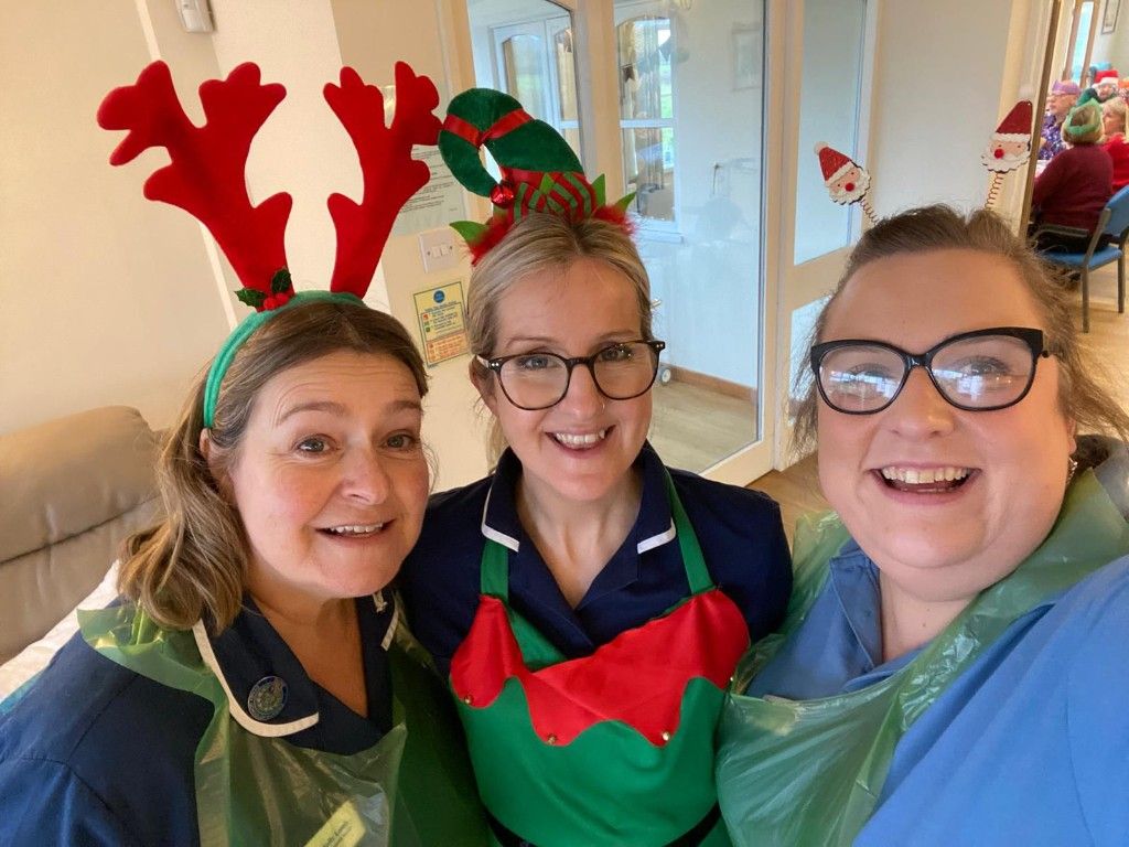 Three Dove Cottage team members smiling together in festive attire