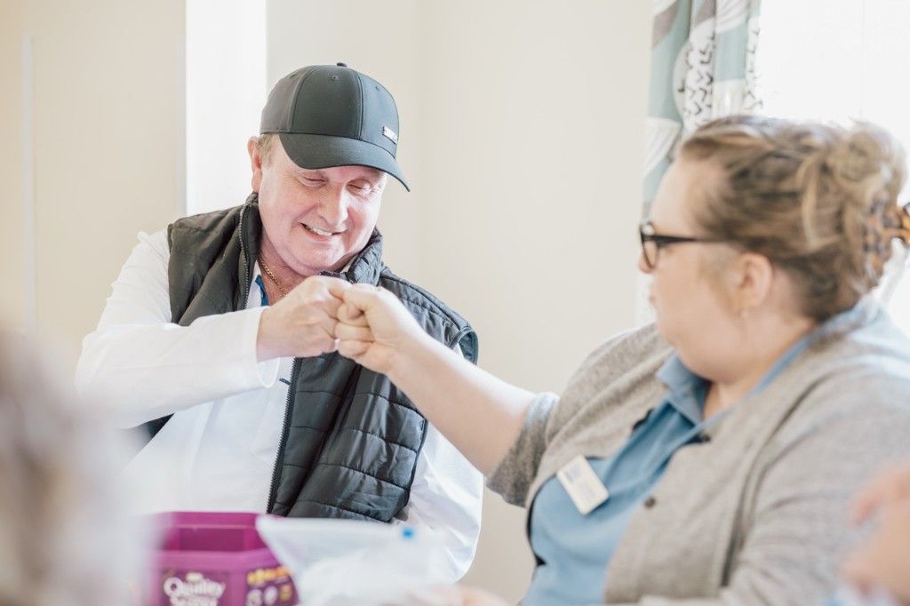 A guest and staff member sharing a supportive fist bump during a group session