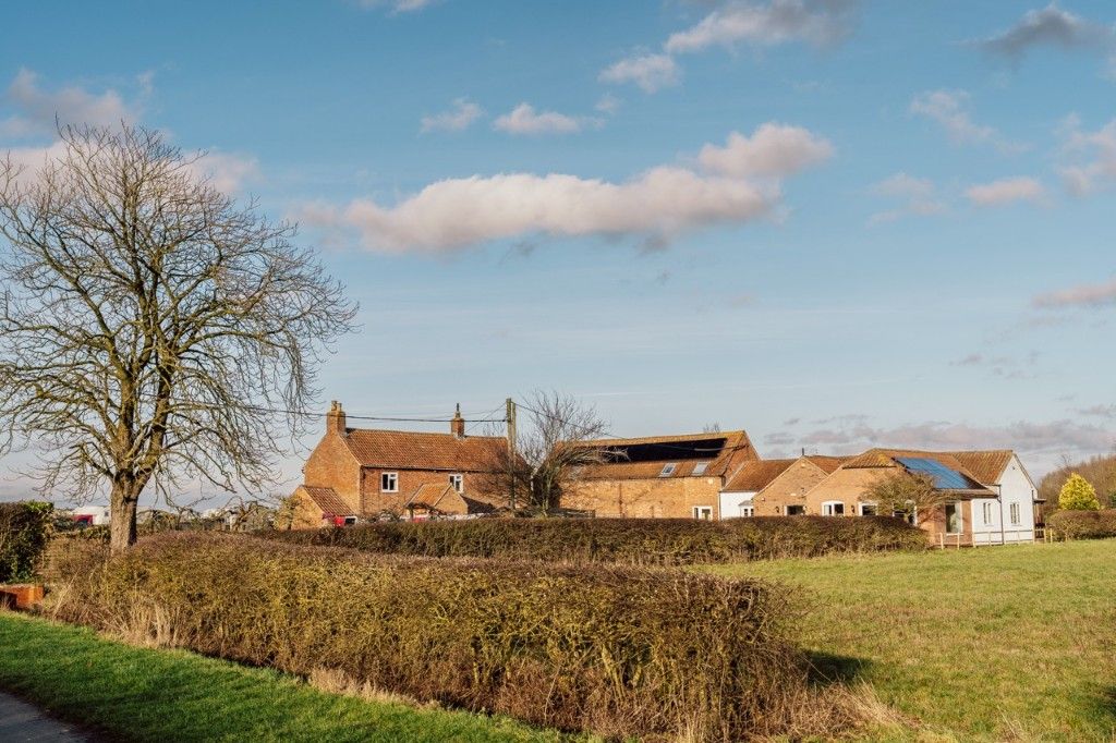 External view of the hospice and gardens across fields